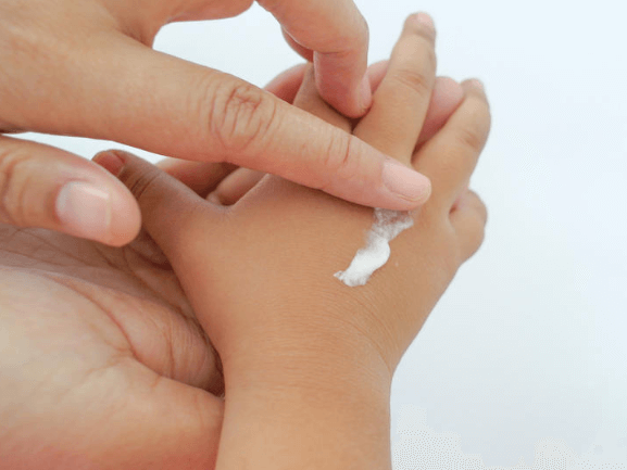 Applying Sunscreen on babies hand