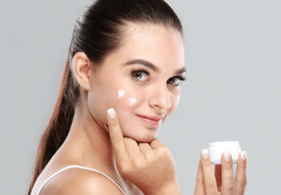 woman applying moisturiser to face