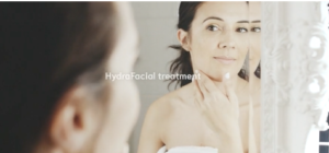 HydraFacial Treatment, lady looking at her skin in the mirror. 