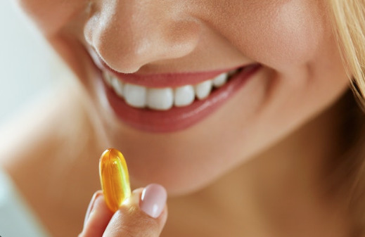 Multivitamins - Skin Benefits, Lady taking a vitamin tablet